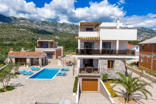 a villa with a swimming pool and a house at Villa Grandioza in Seline