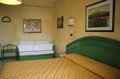 a bedroom with a bed and a chair in it at Hotel Kyrton in Forte dei Marmi