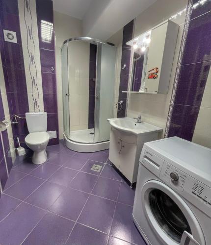 łazienka z pralką i toaletą w obiekcie Sunset Sea View Apartament w Mamai