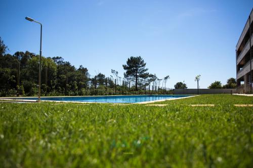 an empty swimming pool with green grass and a street light at AgrellaMar - by TonsdeVerde in Braga