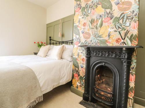 a bedroom with a fireplace next to a bed at No 19, Haworth in Keighley