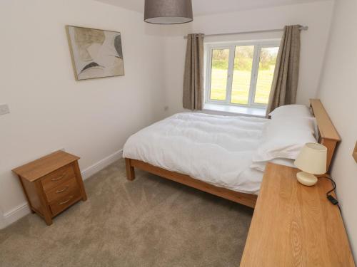 a bedroom with a bed and a window and a table at Bryngwyn in Haverfordwest