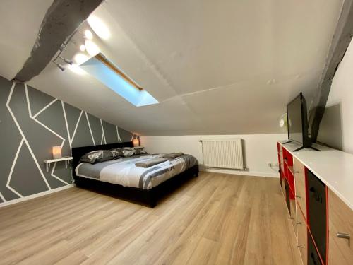 a bedroom with a bed and a flat screen tv at LE MOBILE - Climatisé - Proche de la gare - Centre ville-PROPERTY RENTAL NM in Périgueux