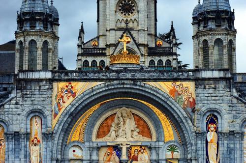 a large building with a clock tower on it at Villa Mariale by Popinns in Lourdes