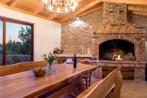 a stone fireplace in a kitchen with a wooden table at Villa Grandioza in Seline