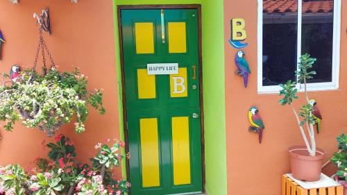a green door on the side of a house with plants at Terrakota Apartments in Willemstad