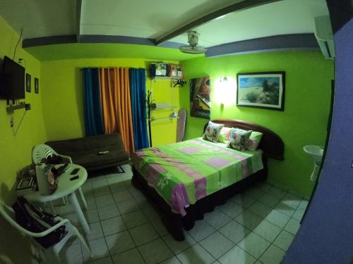 a small bedroom with a bed and a chair at Terrakota Apartments in Willemstad