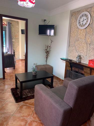 a living room with a couch and a table and a clock at Casa da Avo in Geres