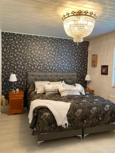 Un dormitorio con una cama grande y una lámpara de araña. en Vanha omakotitalo, 3km Olavinlinnaan, en Savonlinna