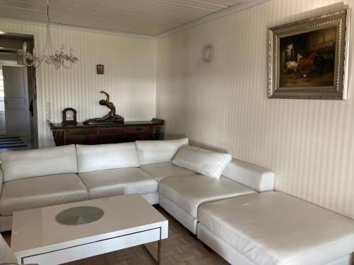 a living room with a white couch and a table at Vanha omakotitalo, 3km Olavinlinnaan in Savonlinna