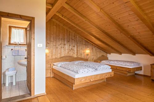 1 dormitorio con 2 camas y baño en Ferienwohnung Sonnenblume Nusserhof, en Avelengo