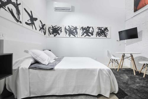 Dormitorio blanco con cama y mesa en TRIANA MODERN y LUXURY, en Sevilla