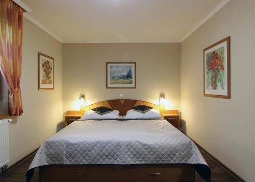 a bedroom with a large bed with two lamps at Penzion U Vlků in Valtice