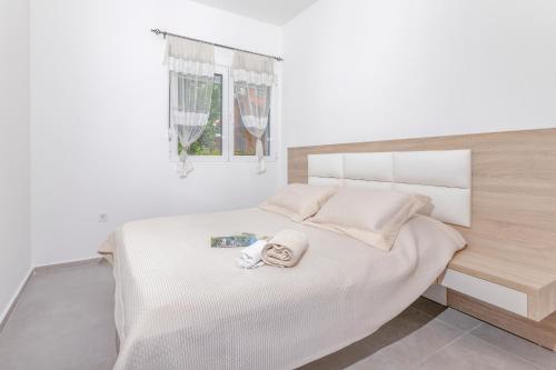 a white bedroom with a bed with a towel on it at Apartments Stetonn in Kotor