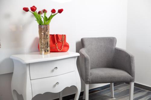 a vase of red tulips sitting next to a chair at Villa Grandioza in Seline