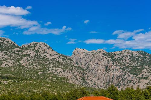 a mountain range with a red roof and a house at Villa Grandioza in Seline