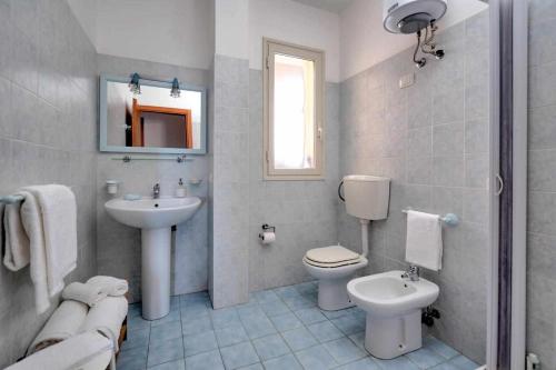 La salle de bains blanche est pourvue d'un lavabo et de toilettes. dans l'établissement appartamento la veranda sul mare a Sampieri, à Sampieri