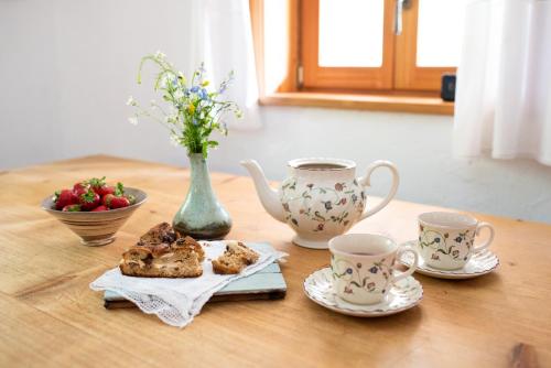 une table avec deux tasses de thé et une assiette de nourriture dans l'établissement Wild flower cottage in Trenta, à Trenta