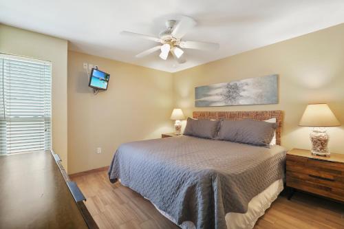 a bedroom with a bed and a ceiling fan at Ground floor beachfront beauty! Steps to the beach and pool in South Padre Island