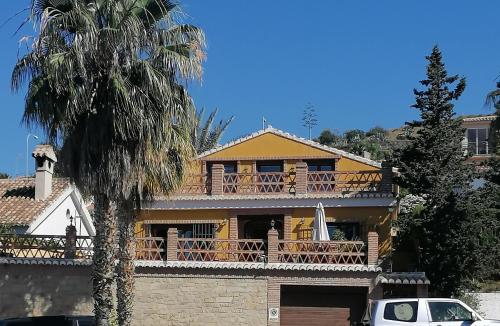 アルムニェーカルにあるCasa de la Galeraの木製バルコニー付きの大きな黄色の家