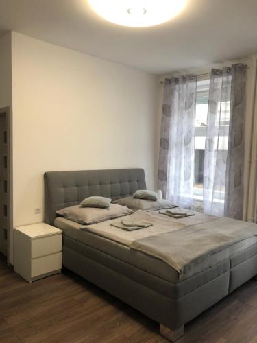 a bedroom with a bed and a large window at Apartman Hanna in Karlovy Vary