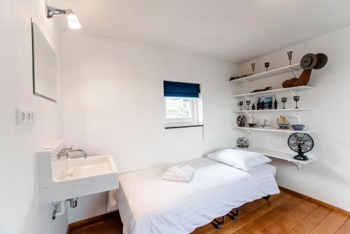 a white room with a bed and a sink at Family Villa behind the Beach in Zandvoort