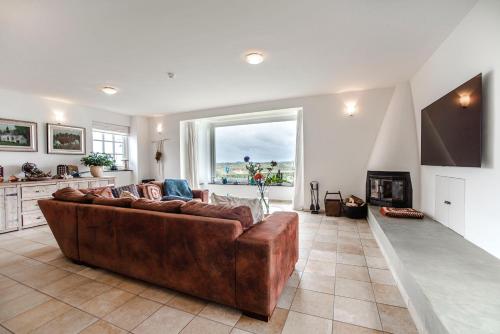 a large living room with a brown leather couch at Family Villa behind the Beach in Zandvoort