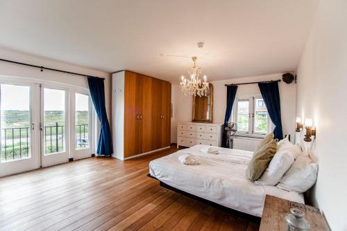 a bedroom with a large bed and a chandelier at Family Villa behind the Beach in Zandvoort