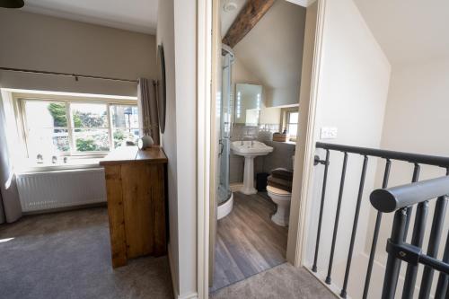 a bathroom with a sink and a toilet and a window at Thornes Cottage in Huddersfield