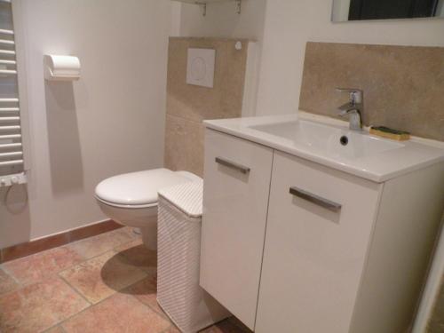 a bathroom with a white sink and a toilet at Un petit coin de Paradis in Mazan
