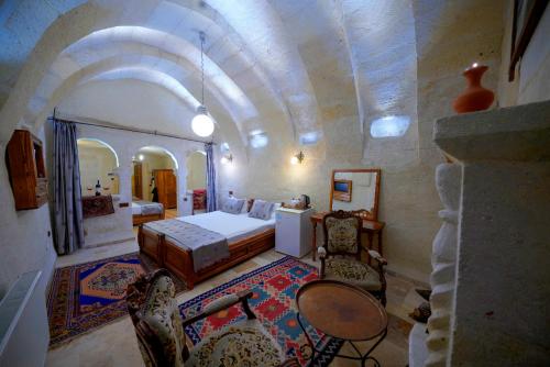 a bedroom with a bed and a table and chairs at Elysee Cave House in Goreme
