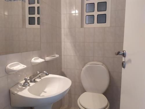 a bathroom with a white toilet and a sink at Los Jazmines II in Tandil