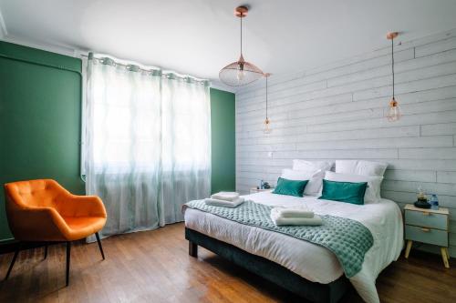 een slaapkamer met een bed en een oranje stoel bij Gîte La Parenthèse 14 personnes in Loisy-sur-Marne