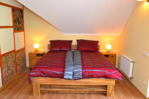 a large bed with red sheets in a room at Villam Apartment in Maribor