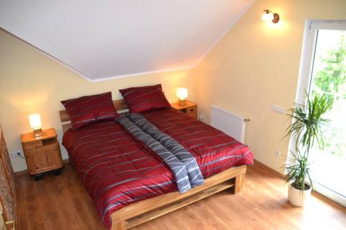 a bedroom with a red bed with two pillows at Villam Apartment in Maribor