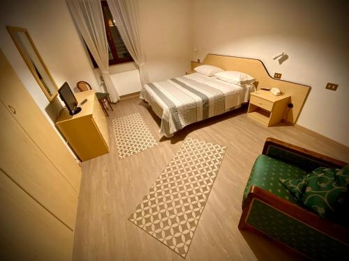 アルタ・テルメにあるHotel Cellaの小さなベッドルーム(ベッド1台、テーブル付)