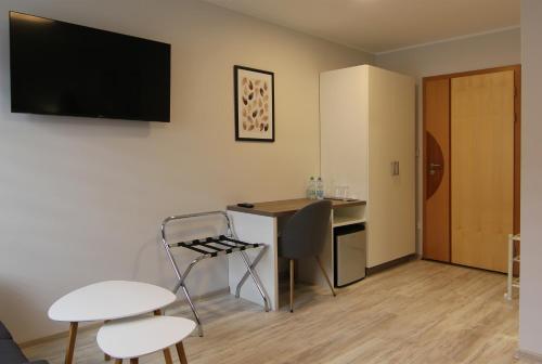 a room with a desk and a table and chairs at Penzion U Vlků in Valtice