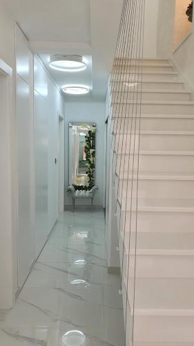 a hallway with white walls and a staircase with a mirror at Casa Aurelia - Aurelia Design in Krk
