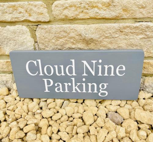 a sign that reads cloud nine parking on a stone wall at Cotswold Chic Retreats "Cloud Nine" Central Chipping Campden-Parking-Garden in Chipping Campden