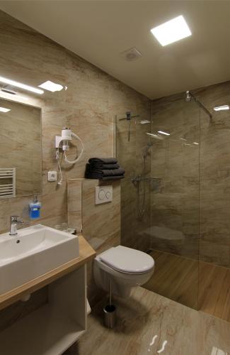 a bathroom with a sink toilet and a shower at Penzion U Vlků in Valtice