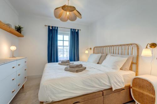 - une chambre avec un lit blanc et des serviettes dans l'établissement Casa Golden Bamboo, private patio & 100m from the river!, à Vila Nova de Milfontes
