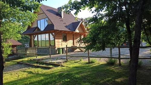 a wooden cabin with a gambrel roof at Dom Królewski Róg in Giżycko