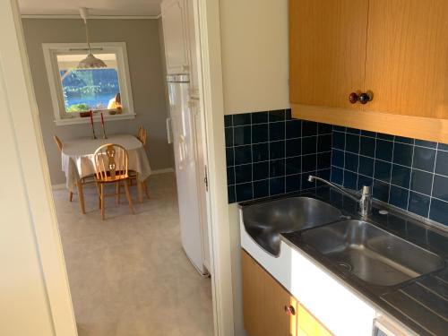 eine Küche mit einem Waschbecken und einem Tisch mit einem Esszimmer in der Unterkunft Dispen feriehus in Stryn