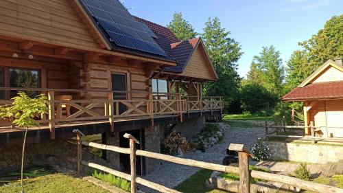 a log cabin with solar panels on the roof at Dom Królewski Róg in Giżycko