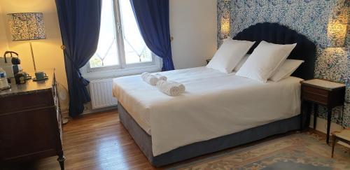 a bedroom with a large bed with towels on it at LA MAISON LEONARD in Bléré
