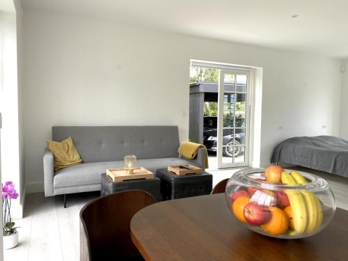 una sala de estar con una mesa con un bol de fruta. en The Beach House Suite, en Karlslunde