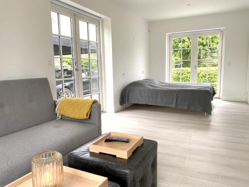 sala de estar con sofá y cama en The Beach House Suite, en Karlslunde