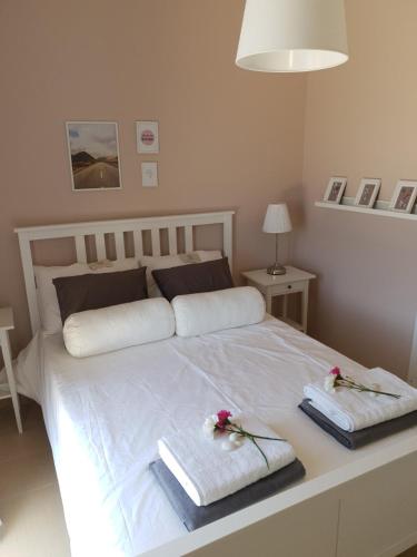 a bedroom with a white bed with towels on it at Villa Clio in Mánganos