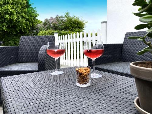 two glasses of wine sitting on an outdoor table at The Beach House Suite in Karlslunde