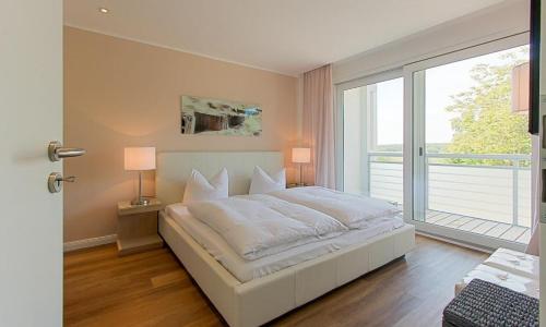 Un dormitorio con una cama blanca y una ventana grande. en Blue Sky, en Dierhagen